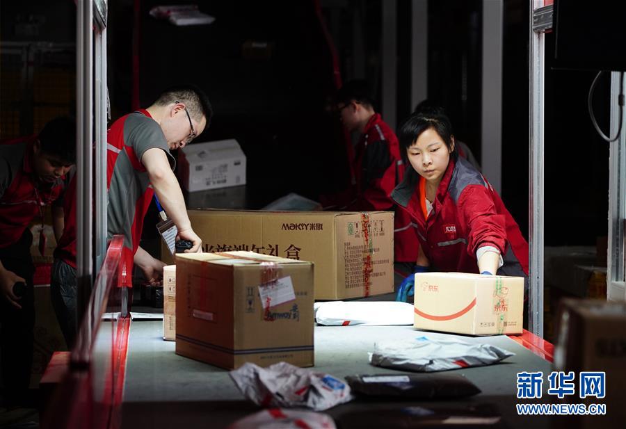 工人在位于西安的京东智能物流中心细分区龙门架下整理包裹（6月3日摄）。龙门架扫描后，包裹的出库物流信息将自动更新。