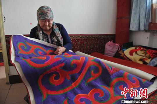 图为哈萨克族手工艺人制作毡垫。　杨艳敏 摄